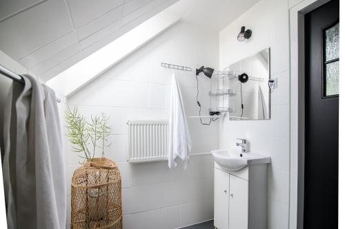 W białej łazience znajduje się umywalka i lustro. w obiekcie Willa Pod Termą - obok Termy Bania w mieście Białka Tatrzanska