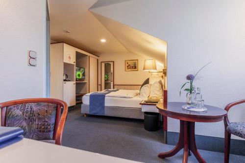 a hotel room with a bed and a table and a chair at Stadthotel Geis in Bad Neustadt an der Saale
