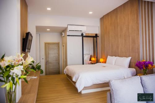 a hotel room with a bed and a tv at Home by the Bridge Hotel in Kamphaeng Phet