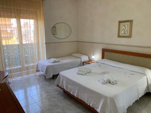 een hotelkamer met 2 bedden en een spiegel bij Playa Apartment in Catania
