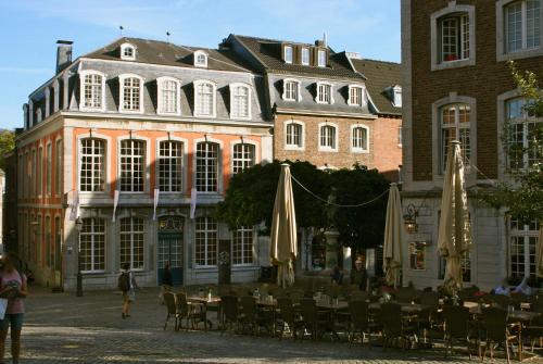 a group of tables and umbrellas in front of a building at Het Mergelhoek 2 in Vaals