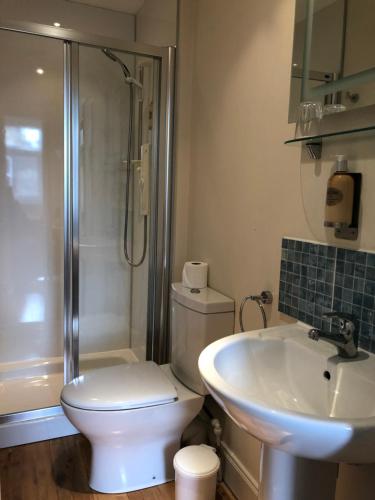 y baño con aseo, lavabo y ducha. en Montague Guest House en St Andrews