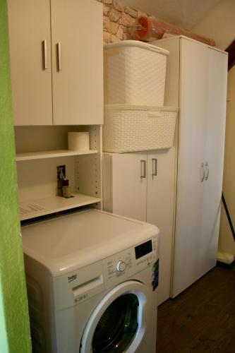 a washer and dryer in a kitchen with a refrigerator at Het Mergelhoek 2 in Vaals