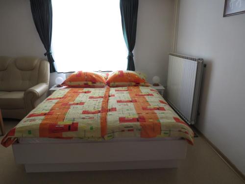 ein Bett mit einer Decke in einem Schlafzimmer in der Unterkunft D-D in Bovec