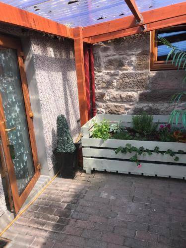 a building with a patio with two planters with plants at Garfield Guesthouse in Dingwall