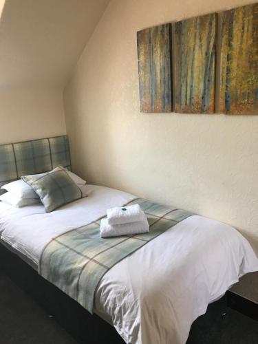 a bedroom with a bed with a towel on it at Garfield Guesthouse in Dingwall