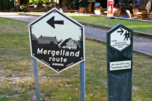 two street signs in the grass in front of a building at Het Mergelhoek 2 in Vaals
