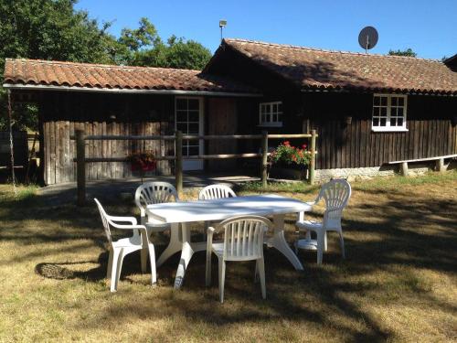 a table and chairs in front of a cabin at Gîte Péchot in Luxey