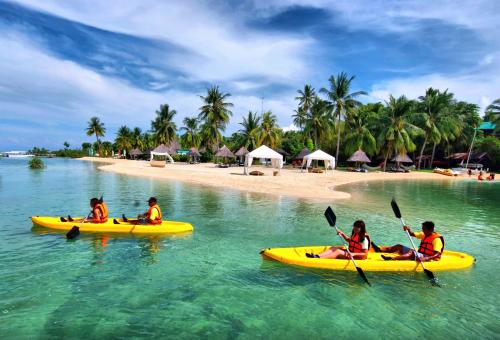a group of people in kayaks in the water on a beach at Badian Island Wellness Resort in Badian