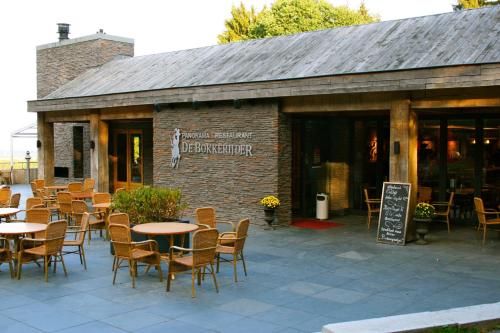 a restaurant with tables and chairs in front of a building at Het Mergelhoek 2 in Vaals