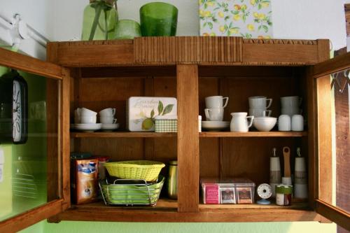 a wooden shelf with cups and dishes on it at Het Mergelhoek 2 in Vaals