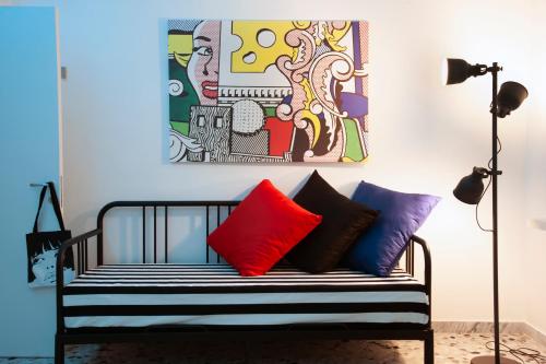 un banco con almohadas coloridas en una habitación con una pintura en Plinio Seniore, en Castellammare di Stabia