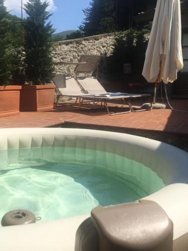 - un bain à remous avec une chaise et un parasol dans l'établissement River Idyll, à Bagni di Lucca