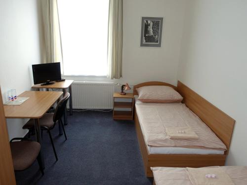 a room with two beds and a desk with a computer at HOTEL STAŘÍČ in Jeseník