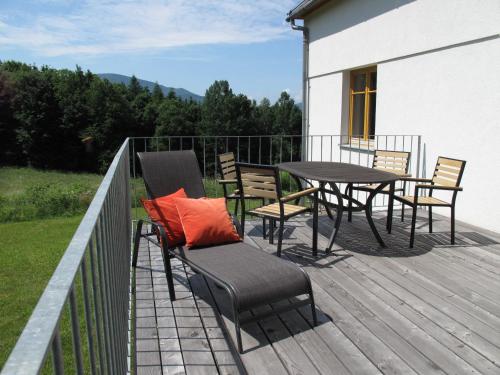 a patio with a table and chairs on a deck at Apartmány na hájovně in Jeseník