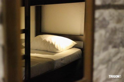 a reflection of a bed with a pillow in a mirror at Trigona Guest House & Hostel in Gjirokastër