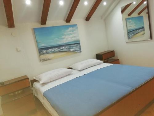 a bedroom with a large bed with two pillows at Apartman Kristina, studio i soba in Primošten