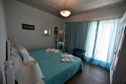 a bedroom with a bed with two towels on it at Heliades Maisonettes in Mithymna