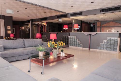 a living room with a couch and a table with flowers on it at Hotel Victory in Athens