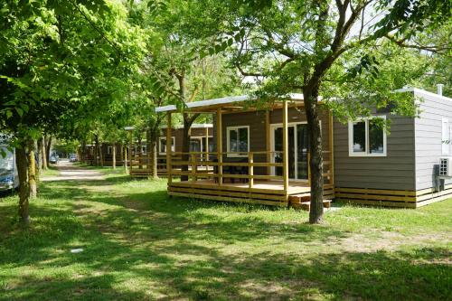 una fila de casas modulares en un parque con árboles en New Campsite in Camping Ca' Savio, en Cavallino-Treporti