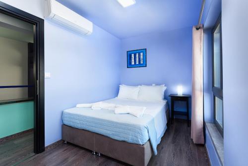 a bedroom with a bed with blue walls at Villa Menelaos in Mochlos