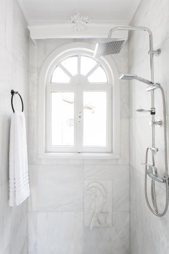 a white bathroom with a shower and a window at Step One | Luxury Suites right in the heart of Acropolis next to metro station in Athens