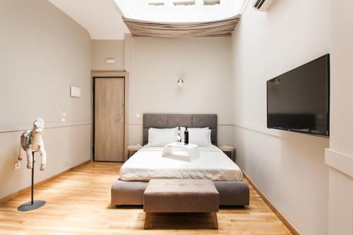 a hotel room with a bed and a television at Step One | Luxury Suites right in the heart of Acropolis next to metro station in Athens