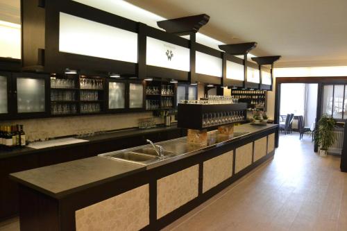 a kitchen with a counter with a sink and a bar at Landhotel Hof Barrl in Schneverdingen