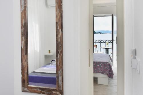 a mirror in a room with a bed and a balcony at Hajdi in Kamenari