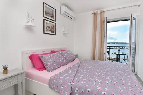 sypialnia z łóżkiem i widokiem na ocean w obiekcie Hajdi w mieście Kamenari