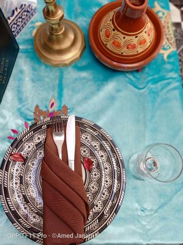 a plate with a fork and knife on a table at Riad Fes Touria Palace in Fès