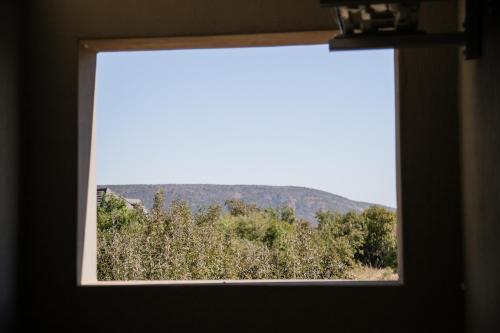 a window with a view of a field of trees at Kuwisa Lodge in Bela-Bela