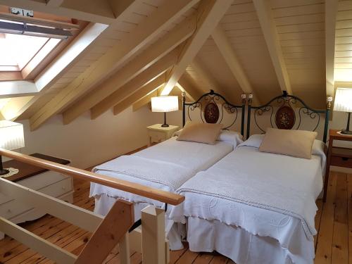 a bedroom with two beds in a attic at Apartamentos Hacienda de Arna in Somo