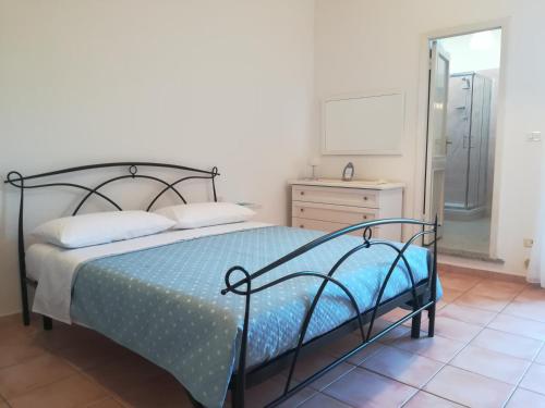 sypialnia z łóżkiem, komodą i lustrem w obiekcie Casa Eleonora w mieście Porto Torres