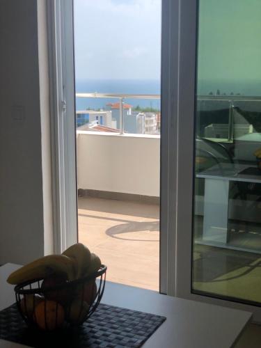 a bowl of fruit sitting on a table in front of a window at Apartmani Dini in Ulcinj