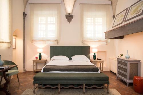 a bedroom with a large bed and two windows at Al Palazzo del Marchese di Camugliano Residenza d'Epoca in Florence