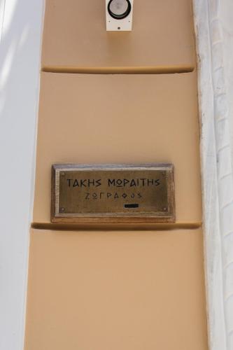 a sign on the side of a wall with a clock at Step One | Luxury Suites right in the heart of Acropolis next to metro station in Athens