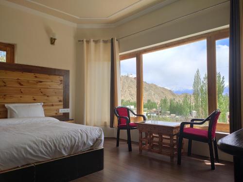 a bedroom with a bed and a table and chairs at Shaolin Ladakh in Leh