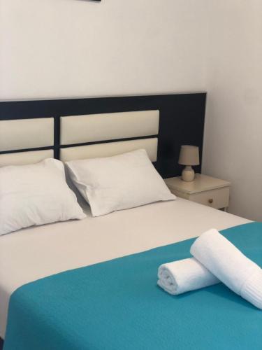 a bedroom with a bed with two towels on it at Apartmani Dini in Ulcinj