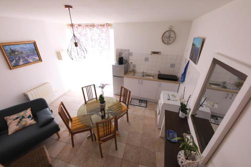 ein Wohnzimmer mit einem Tisch und einer Küche in der Unterkunft Les lavandes de Sèverine in Boulbon