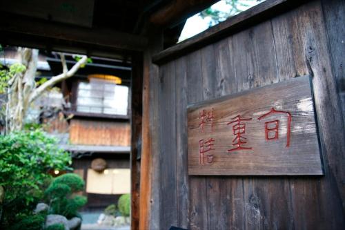 a sign on the side of a wooden building at Hotel Hanakoyado in Kobe