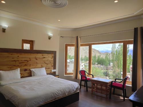 Schlafzimmer mit einem Bett, einem Schreibtisch und einem Fenster in der Unterkunft Shaolin Ladakh in Leh