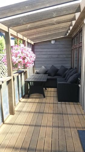 a patio with a couch and a table on a deck at Guest House Baltās Dūjas in Saulkrasti