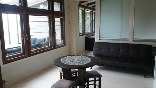 a room with a table and chairs and windows at Guest House Baltās Dūjas in Saulkrasti