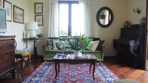 a living room with a couch and a table with flowers at VILLA LE ROSE in Cavour