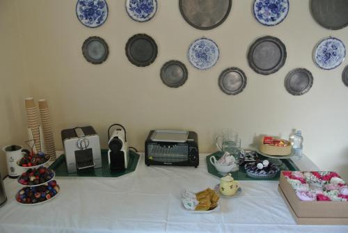 a table with plates on the wall and a table with dishes at VILLA LE ROSE in Cavour