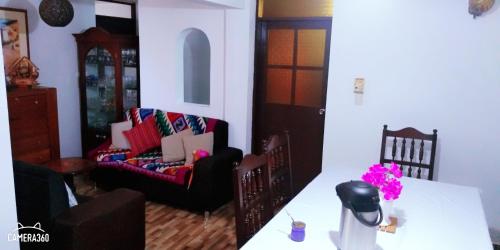 a living room with a table and a chair at La Casa del Che Fernando in Lima