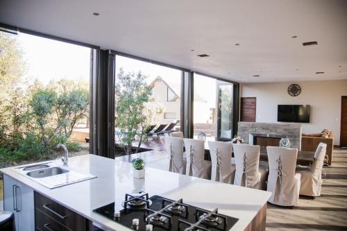 a kitchen and living room with a large window at Kuwisa Lodge in Bela-Bela