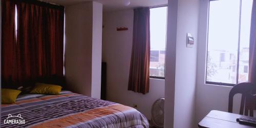a bedroom with a bed and a window and a desk at La Casa del Che Fernando in Lima