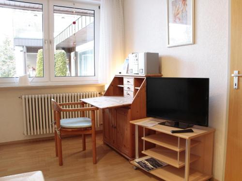a room with a desk with a television and a chair at Ferien-Oase Bad Dürrheim in Bad Dürrheim